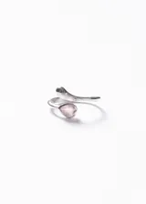Anillo abierto de diseño entrelazado fabricado en plata 925, con un extremo terminado en punta redondeada y el otro engastado con una piedra de cuarzo rosa en forma de gota.