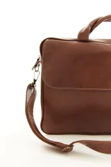 Portafolio de cuero color marrón, con asas superiores reforzadas, correa ajustable desmontable para el hombro y bolsillo exterior con solapa. Diseñado para oficina y uso profesional.