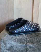 Zuecos negros de cuero vegano con tachas plateadas.