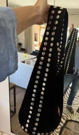 Bolso negro de gamuza con tachas plateadas.