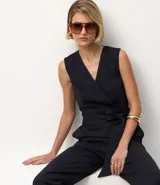 Mono largo sin mangas, confeccionado en tejido Ponto Roma de viscosa certificada, con estampado de rayas verticales finas. Presenta un diseño cruzado en el torso con lazo ajustable a la cintura y pantalón de pierna ancha.