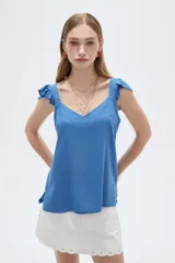 Musculosa amarilla de viscosa, con cuello en V y breteles anchos decorados con volados. Presenta un corte holgado.