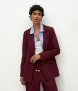 Blazer de sastrería color bordó, con cuello inglés, solapas clásicas y cierre frontal de un solo botón. Confeccionado en una mezcla de viscosa y lino, presenta un corte fluido y elegante.
