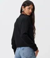 Saco de tricot negro de corte regular, con cuello polo, mangas largas y cierre frontal con botones. Presenta un diseño clásico y versátil.