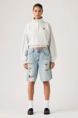 Bermuda de jean tiro medio color celeste claro, estilo baggy con roturas y flecos en los bordes.