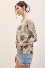 Sweater de punto color beige con estampado geométrico y floral en tonos azules y burdeos, de manga larga y cuello redondo.