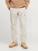 Pantalón cargo color beige de corte relajado, con cierre de gancho y cremallera, bolsillos traseros, frontales y laterales, tiro medio y detalle de cordones en los dobladillos.