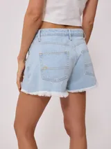 Short de jean azul con roturas y terminaciones desflecadas.