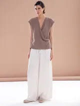 Pantalón palazzo blanco con cintura alta y cordón ajustable.