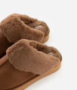 Pantufla abierta de diseño acogedor, confeccionada en poliéster con acabado tipo gamuza y forro de piel sintética. Presenta una suela alta de goma termoplástica que proporciona estabilidad y confort.