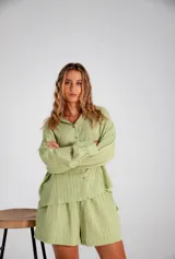 Conjunto compuesto por camisa oversize de manga larga con puños y short con cintura elástica. Ambas prendas presentan un diseño de rayas verticales tono sobre tono con textura suave y fluida.