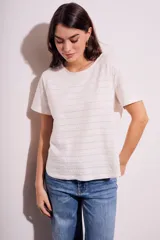 Remera blanca de manga corta con cuello redondo y textura de líneas horizontales con perforaciones.