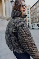 Anorak acolchado de cuello subido y manga larga con puños elásticos ajustables. Presenta un diseño de cuadros, cierre frontal con cremallera, bolsillos laterales con cierre y bajo ajustable con cordones elásticos.