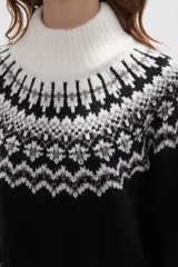 Sweater de punto con diseño jacquard en cuello, puños y ruedo. Presenta cuello alto, mangas largas y corte holgado.