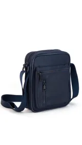 Morral de tela impermeable color negro, de forma rectangular y diseño compacto. Cuenta con correa ajustable para llevar al hombro o cruzado, y múltiples compartimentos con cierre, incluyendo un bolsillo frontal vertical con cierre.