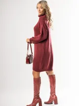 Vestido tipo polerón de tejido de punto grueso, color bordó, con cuello alto, mangas largas y diseño holgado.