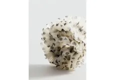 Coletero para el pelo de diseño voluminoso y fruncido, en tejido translúcido de color blanco con estampado de lunares negros.