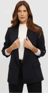 Blazer azul marino de corte sastrero, con solapas clásicas, bolsillos frontales con solapa y mangas tres cuartos con detalle de botón.