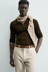 Cinturón de piel color marrón con costuras decorativas en los bordes. Presenta una hebilla metálica rectangular de color plateado y un pasador a juego.