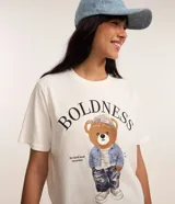 Remera de algodón color crudo, de corte recto y manga corta, con cuello redondo y estampa bordada de un oso vestido con chaqueta de jean, gorro y pantalón.