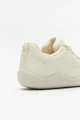 Zapatilla minimalista tipo barefoot de color verde menta, con diseño de suela plana y flexible, confeccionada en material textil transpirable con cordones a tono.