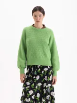 Sweater de tejido de punto color verde, con cuello redondo, mangas largas con hombros caídos y puños acanalados. Presenta un diseño de textura sutil en el frente.