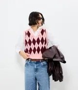 Chaleco de punto con escote en V y diseño de cuadros tipo argyle en tonos rosa y bordó. Presenta terminaciones acanaladas en cuello, sisas y ruedo.