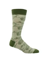 Calcetín de largo medio color verde claro con estampado de montañas y árboles en verde oscuro. El borde superior, el talón y la punta son de color verde oscuro sólido.