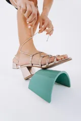 Sandalias de tacón color peltre con tiras finas y cierre con cordones.