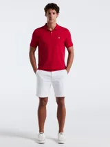 Polo roja de piqué de algodón orgánico, corte recto, cuello con solapa y logo bordado en el pecho.