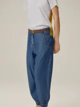 Pantalón de corte relajado color marrón, confeccionado en mezcla de algodón y lino. Presenta cintura con pasacintos, bolsillos laterales y diseño de botamanga ajustable con cordones y elástico.