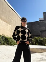 Buzo de tejido de punto color rosa con grandes círculos color borgoña.