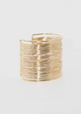 Pulsera brazalete rígido color dorado, con diseño de múltiples hilos finos.