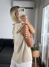 Blusa blanca de símil lino con cuello redondo fruncido, doble volado en las mangas con detalle de encaje.