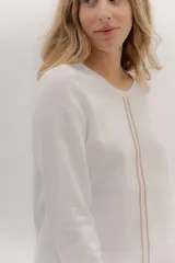 Remera de manga larga con escote a la base, color blanco, con un bordado central de dos líneas negras verticales en la parte delantera. La parte delantera es de lino y la espalda de algodón con spandex.