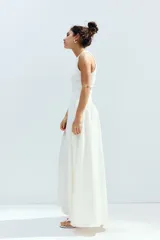 Vestido midi blanco sin mangas con cuello redondo, cuerpo entallado en punto acanalado de algodón y falda amplia con costura fruncida en diagonal.
