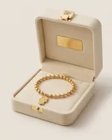 Pulsera de acero italiano con baño de oro, compuesta por una cadena de eslabones de bolitas y un dije colgante en forma de mano de Hamsa.