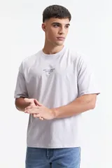 Remera gris de manga corta con corte boxy y estampado en la espalda con una rosa y texto en forma circular.