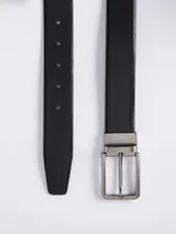 Cinturón reversible de cuero color marrón y negro, con hebilla metálica plateada.