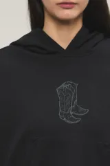 Buzo hoodie oversize negro, confeccionado en rústico de algodón y poliéster, con capucha, bolsillo tipo canguro y detalle de estampa de botas vaqueras con tachas en el centro del pecho.