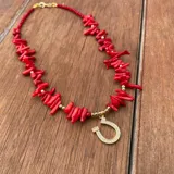 Collar de corales naturales rojos y cuentas doradas, con dije colgante en forma de herradura con apliques de circón.
