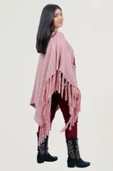 Poncho rojo de tejido artesanal con aplique central de crochet en forma de mandala con tonos amarillos, blancos y rojos. Presenta terminación con flecos en los laterales y diseño holgado.