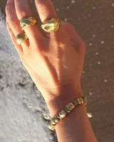 Pulsera artesanal compuesta por una serie de cuentas metálicas irregulares ensartadas en un hilo de algodón natural. Diseño rústico y minimalista.