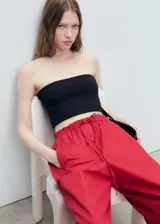 Pantalón rojo de corte holgado y pernera ancha, con cintura elástica fruncida y cordón ajustable.