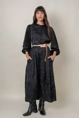 Vestido midi negro con estampado floral, mangas largas abullonadas con puños elastizados, cuello mao y cinturón fino color cobre.