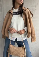 Sweater de punto color natural con cuello redondo y detalle de guarda tejida en la parte superior del pecho. Presenta mangas largas con puños acanalados y un diseño de corte recto.