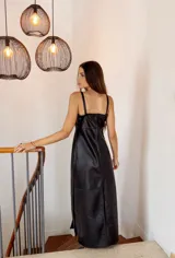 Vestido largo negro de cuero sintético, con breteles finos y corte recto con aberturas laterales.
