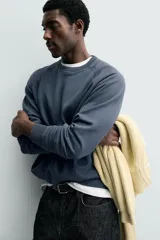 Sudadera regular fit color azul, de cuello redondo, manga larga ranglán y efecto lavado con acabados en rib.