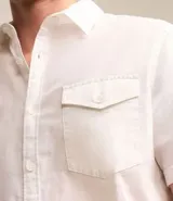 Camisa de hombre de manga corta color marrón, confeccionada en lino y algodón. Presenta cuello clásico, botonadura frontal, bolsillo en el pecho y mangas con botón para enrollar.