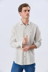 Camisa de lino rayada de manga larga, con cuello camisero, cierre frontal de botones y bordado sutil en el pecho.